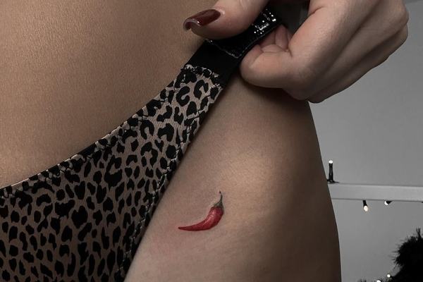 Mały tatuaż papryczki przy linii bikini — trudna strefa