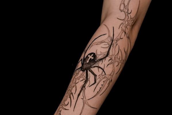 Tatuaż pająka na przedramieniu — unikaj tarcia tkanin