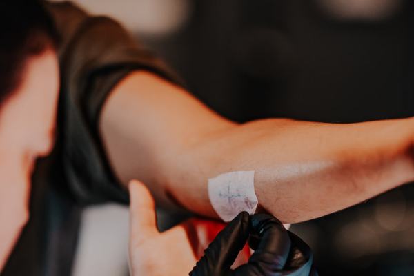 Tatuażysta w rękawiczkach przygotowuje skórę klienta