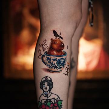 Tatuaż na łydce: kapibara w filiżance, ptak