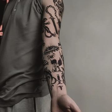 Przedramię z kompozycją czarnych tatuaży różnej skali