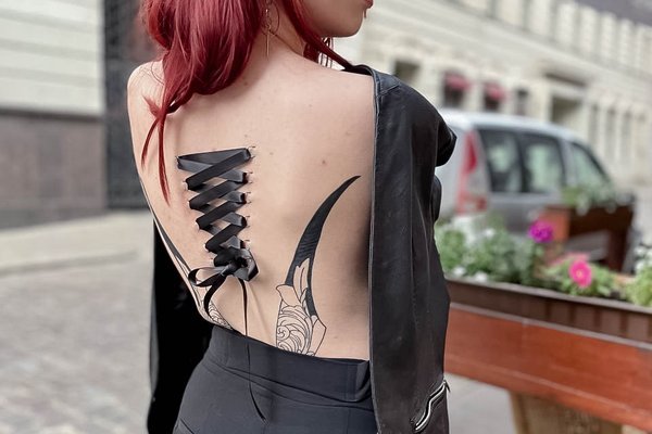 Play piercing: gorset z czarnej wstążki na plecach