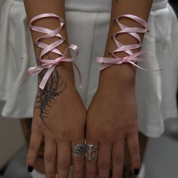 Różowe wstążki gorsetowe na nadgarstkach
