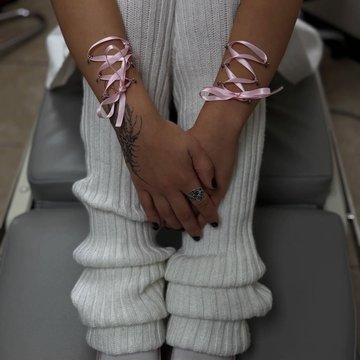 Play piercing: różowe wstążki gorsetowe na nadgarstkach