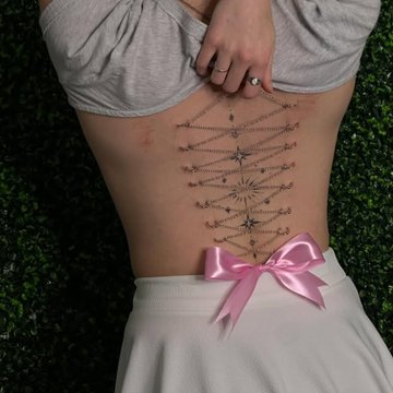 Play piercing: łańcuszkowy gorset na plecach, kokarda