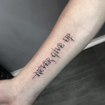 Tatuaż Never Give Up z ozdobnym fontem