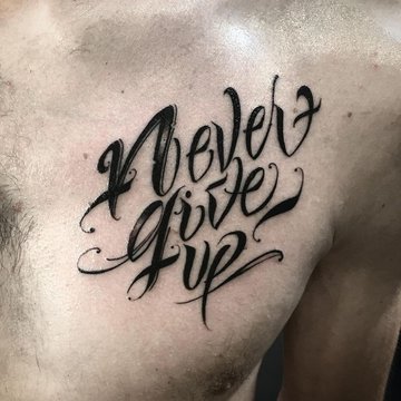 Męski tatuaż Never Give Up na klatce piersiowej
