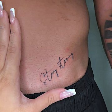 Pierwszy tatuaż męski z napisem „Stay strong” na żebrach