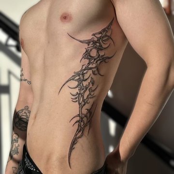 Tatuaż tribal na żebrach męski siła i energia