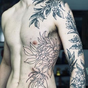 Tatuaż kwiat na żebrach męski subtelny kontrast między siłą a naturą