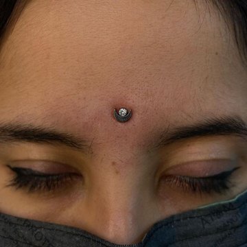 Microdermal na czole: księżyc z kryształkiem